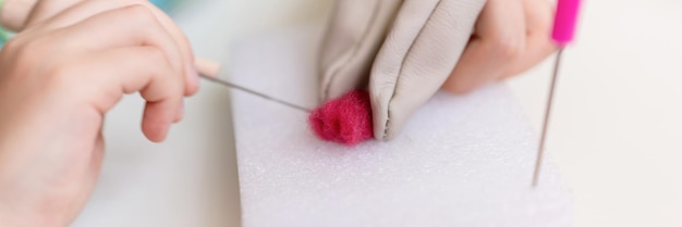 Ręka trzymająca igłę nad tkaniną